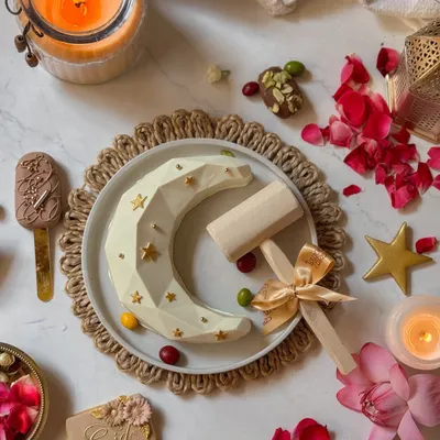 My Eid piñata set, featuring the geometric white chocolate moon, a decorated cookie, a cakesicle, and the wooden hammer to break into the fun. It's an interactive centerpiece for your Eid celebration.