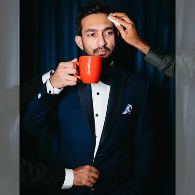 The groom's swag mode: activated. We love this creative shot of Azhir, calm with his coffee, while his groomsmen get him ready for the big moment.