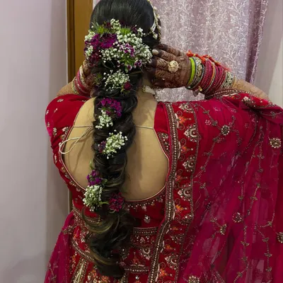 A stunning bridal braid adorned with fresh purple and white flowers. I teach my students how to securely incorporate flowers and other accessories into hairstyles.