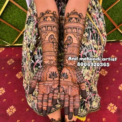 A classic full-hand bridal mehandi with royal motifs. This design features peacocks, lotus flowers, and palace-style architecture (jharokhas) for a truly regal look.