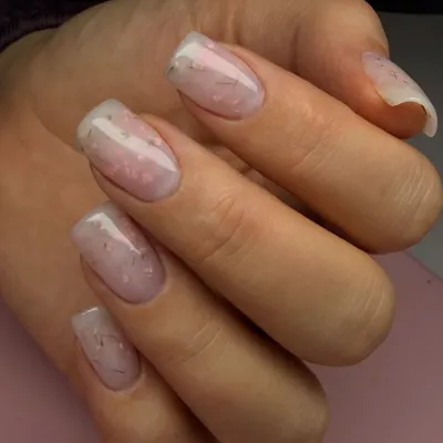 A perfect example of a hard gel overlay. This technique adds strength and structure to natural nails, as seen here with this beautiful milky manicure with delicate embedded threads.