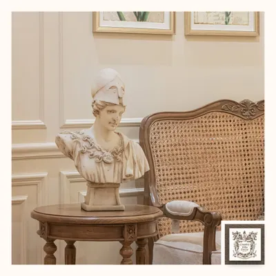 This classical bust of the Greek goddess Athena adds an element of wisdom and artistry to any room. Placed on a side table next to a classic cane chair, it creates a corner of timeless elegance.