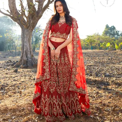For the bride who wants a classic look, this intricate red bridal lehenga is a dream come true. The detailed embroidery and cape-style dupatta create a regal silhouette for your big day.