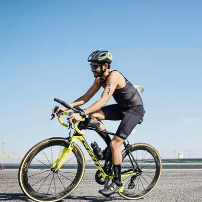 Focused and aerodynamic during the cycling leg of the Ironman 70.3 Bahrain. Our training prepares athletes for every segment of a triathlon, from swimming to this crucial bike portion.