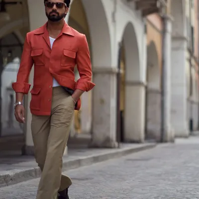 Our linen safari jacket in a vibrant Aperol spritz orange. This piece is perfect for warm days and cool evenings, offering a stylish layer for your travels.