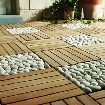 This image showcases an innovative flooring concept, combining the warmth of wooden deck tiles with the natural, textured look of white river pebbles. This method is great for creating visual interest and defining different areas.