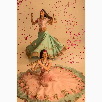 A creative fashion photograph for an Indian ethnic wear brand. The dynamic poses and falling petals create a whimsical and visually rich narrative for the collection's lookbook.