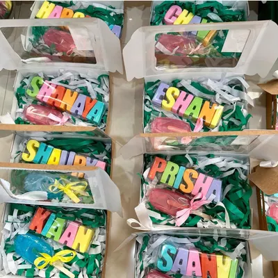 A vibrant display of personalized return gift boxes, each featuring a colorful name soap and a matching popsicle soap. This is a budget-friendly yet impactful way to thank guests at your child's party.