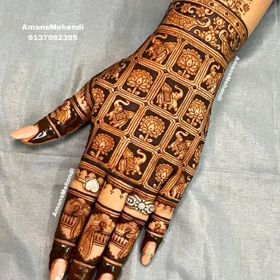 A stunning grid pattern on the back of the hand. Each square is filled with an alternating elephant or lotus motif, creating a design that is both intricate and orderly.