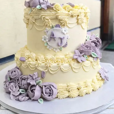 This two-tier vintage engagement cake is one of my absolute favorites. I find the process of creating these intricate buttercream piped details and delicate lavender roses so therapeutic, and the result is a timeless centerpiece.