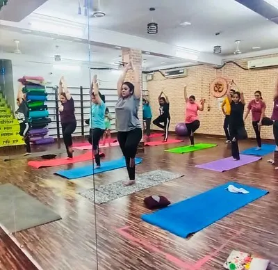 A full house for our morning group yoga session. You can see the energy as everyone holds the tree pose, finding their balance together in our spacious, mirrored studio.