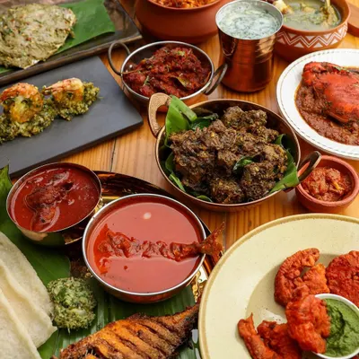 A lavish spread of authentic Konkani food, featuring fried fish, prawns, and various curries, styled to look like a generous family feast.