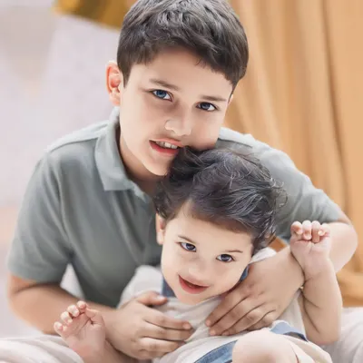 The protective and loving embrace of an older brother. These are the sibling moments that build a lifelong bond, captured in a simple, heartfelt portrait.
