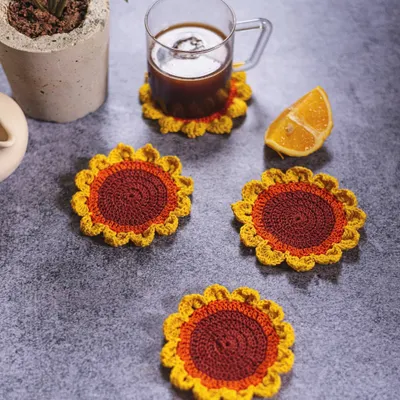 Our sunflower coasters bring sunshine to any table setting. This lifestyle shot shows how a set of four can brighten up your coffee time while keeping your surfaces clean from water rings.