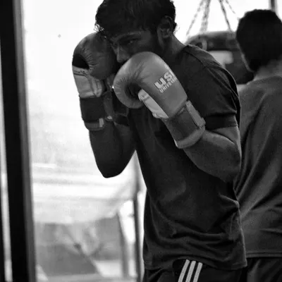 A fighter working on his form, keeping his guard tight while training. The bag doesn't hit back, so your discipline has to be perfect.