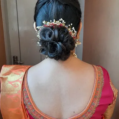 An elegant and intricate low messy bun. This hairstyle is perfect for a reception or engagement, and I've added a delicate, custom hair accessory to complement the saree.