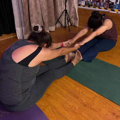 A perfect day includes a good stretch. Here, I'm assisting a student in a partner stretch to deepen her forward bend and increase hamstring flexibility.