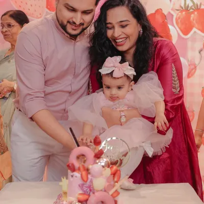 This photo from Gauri's first birthday showcases the stunning strawberry-themed cake from a local baker. By tagging and praising the creator, I show how I support and promote small businesses through my celebration content.