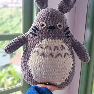 A close-up of the finished large Totoro plushie, made with soft, thick yarn for extra cuddliness. The details include his whiskers, grey belly markings, and big, friendly eyes.