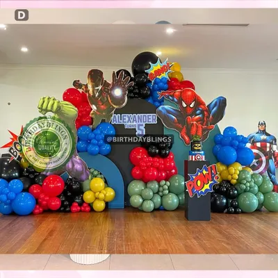 An epic Avengers-themed birthday party, assembling Iron Man, Spider-Man, Captain America, and the Hulk. The setup features a multi-panel city skyline backdrop and balloon colors matching each hero.