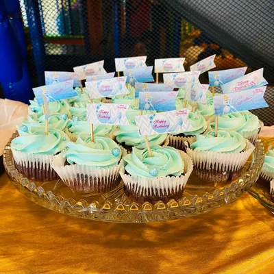 Cinderella-themed chocolate cupcakes with a gorgeous blue vanilla buttercream frosting and "Happy Birthday" flags, perfect for a princess party.