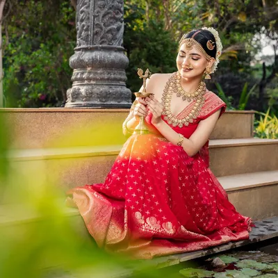 A serene moment from a beautiful photoshoot. The model is wearing a traditional red lehenga with one of my antique gold necklace sets, creating a timeless and elegant look.