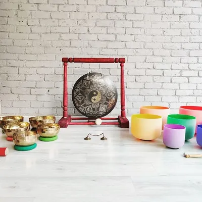 A complete setup for a profound sound journey. This arrangement showcases the harmonious blend of metal and crystal, with hand-hammered Tibetan bowls, frosted crystal bowls, and a central gong.