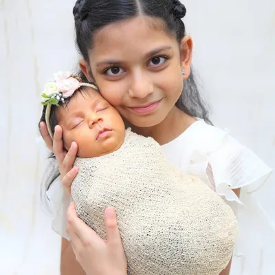 The bond between siblings is so special. I gently guide older children to hold their new baby brother or sister safely, capturing that instant connection and creating a memory the family will treasure forever.
