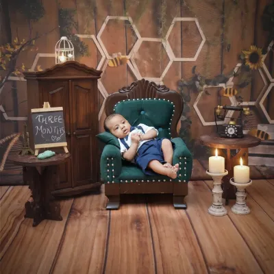 A three-month milestone session. This little gentleman is relaxing in a miniature armchair, with a chalkboard sign marking his age.