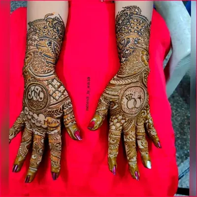 Your mehendi should tell your love story. Here, I incorporated the couple's initials and their engagement rings into the design, making it a truly personal piece of art for their special day.