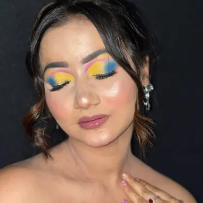A close-up of a vibrant, multi-colored eyeshadow look, blending yellow, pink, and blue for a creative effect.