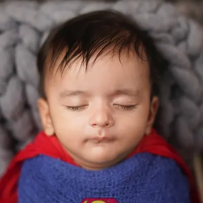 A close-up of our little Superman, sleeping peacefully. Even superheroes need their naps. Themed newborn shoots are a fun way to incorporate your family's interests.