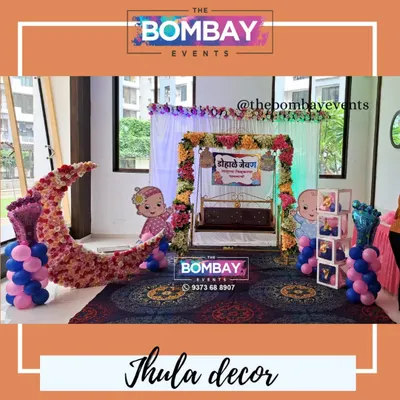A beautiful Dohale Jevan decoration in a sunlit room, featuring a floral jhula, a crescent moon prop, and baby cutouts. This setup is perfect for daytime functions.