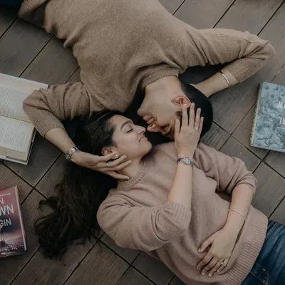 An overhead shot of a couple lost in their own world, surrounded by books. This creative angle provides a unique and intimate view of their connection.