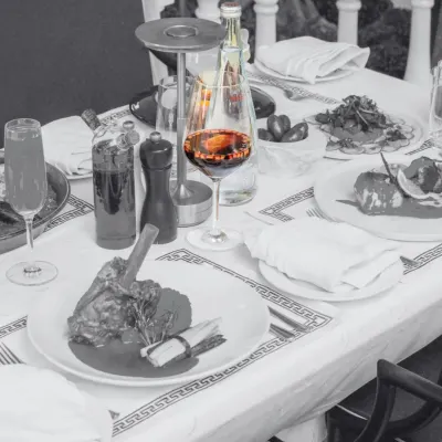A glass of rich red wine is the centerpiece of this table setting. Wine is an essential part of the Mediterranean dining culture, and we help you find the perfect pairing for your meal.