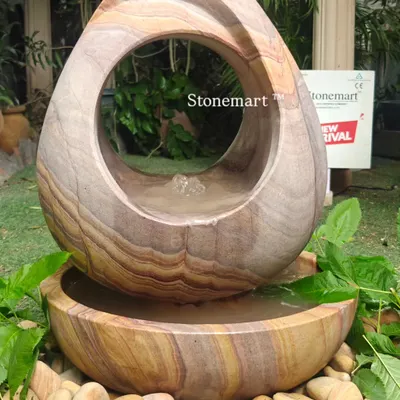 This modern fountain, carved from Rainbow Sandstone, is one of my most popular international designs. The abstract, hollowed-out egg shape creates a unique water flow and visual appeal, perfect for a contemporary garden or patio.