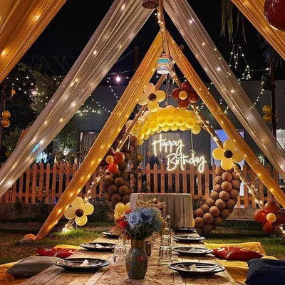 This is a complete view of my intimate cabana dinner setup. It features a low wooden table, colorful cushions for comfortable floor seating, and a beautifully set table, all under a canopy of glowing lights.