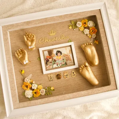 This beautiful keepsake features golden casts for baby Cherisha, set against a warm, wood-textured background. It is personalized with a central photo, her name, birth stats, and lovely floral decorations.