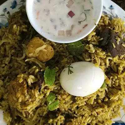 My Gongura Chicken Biryani, a tangy and spicy specialty from Andhra. The unique flavor comes from the gongura (sorrel leaves) paste, served here with a boiled egg and fresh raita.