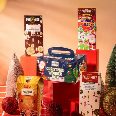 A Christmas-themed product lineup for Paul & Mike chocolates. This shot is styled for a seasonal campaign, showcasing a gift box and multiple products.