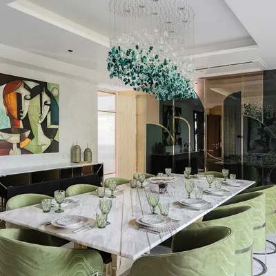 This dining room was planned as a central moment for gathering. The layout allows the design to breathe, with tonal greens in the chairs, soft marble textures on the table, and a sculptural chandelier suspended like an artwork.