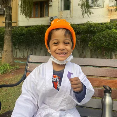 Nothing beats a big smile during an outdoor karate session. This little student is enjoying the fresh air while learning new skills, showing that fitness for kids can be pure fun.