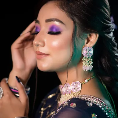 A bold and artistic party look. The vibrant purple eyeshadow is the star of the show, creating a dramatic and eye-catching effect perfect for a sangeet night.