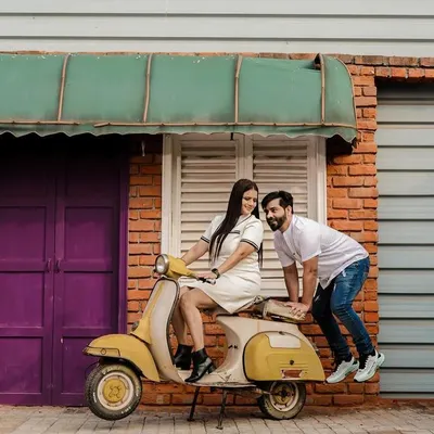 Let's have some fun with props. This couple wanted a playful vibe, so we used a vintage scooter against a quirky, colorful brick wall. This kind of shot is full of energy and personality, perfect for couples who want their pre-wedding photos to be lighthearted and memorable.
