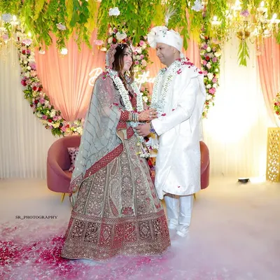 A magical moment from the jaimala ceremony, with the couple surrounded by smoke effects and floral decor. This is a core memory of the wedding day.