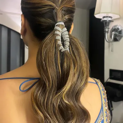 This is a new favorite of mine: a braided ponytail with a sparkling accessory. I created a small braid at the crown and wrapped the base of the wavy ponytail with a beautiful rhinestone cuff for a touch of glamour.