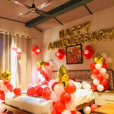 A simple yet beautiful bedroom decoration to celebrate your anniversary. This package includes "Happy Anniversary" foil balloons on the wall, with balloon bunches and star foils in a classic red, white, and gold color scheme.