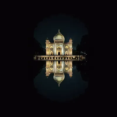 Safdarjung's Tomb illuminated at night, its reflection captured in the water feature, framed by a traditional Mughal arch. This is a shot I took for an OPPO campaign.