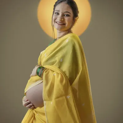 Radiating joy in a traditional yellow saree, this mother to be is a picture of grace. The halo of light behind her symbolizes the divine feminine energy of creating life.