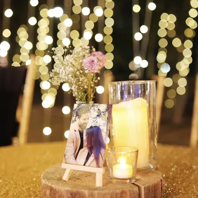 A personalized centerpiece featuring a photo of the couple on a small easel, surrounded by candles and flowers. It's a beautiful way to share your story with guests.